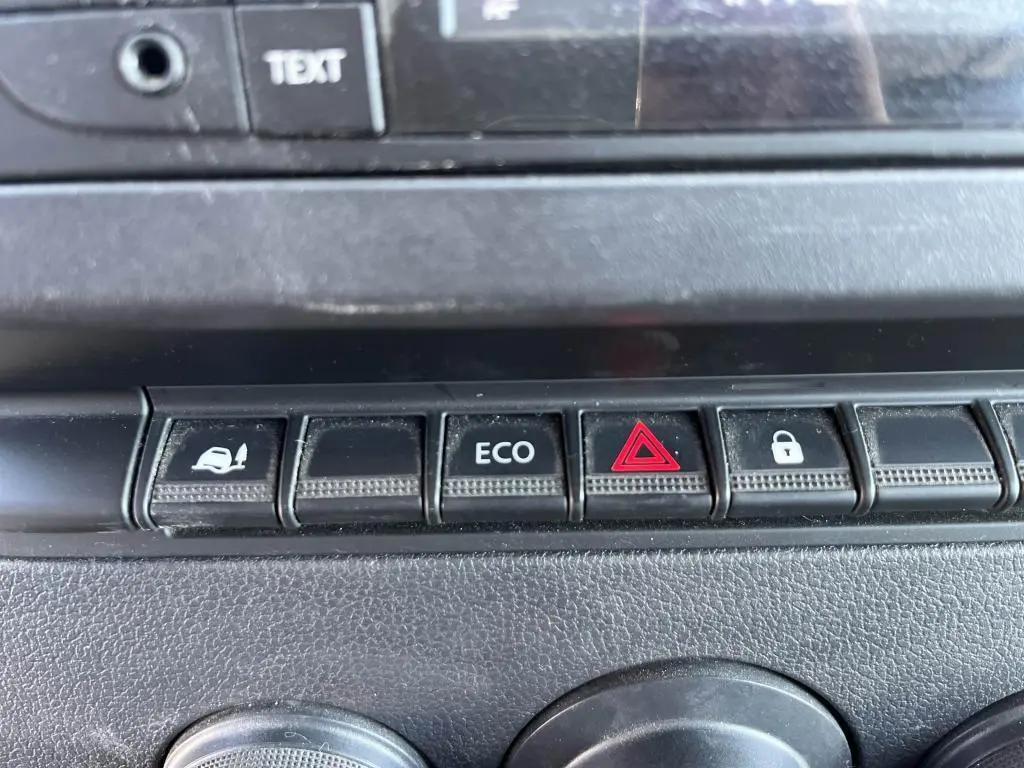 Gros plan sur les boutons de commande du tableau de bord du Renault Master blanc, avec touche ECO et alerte triangle rouge.