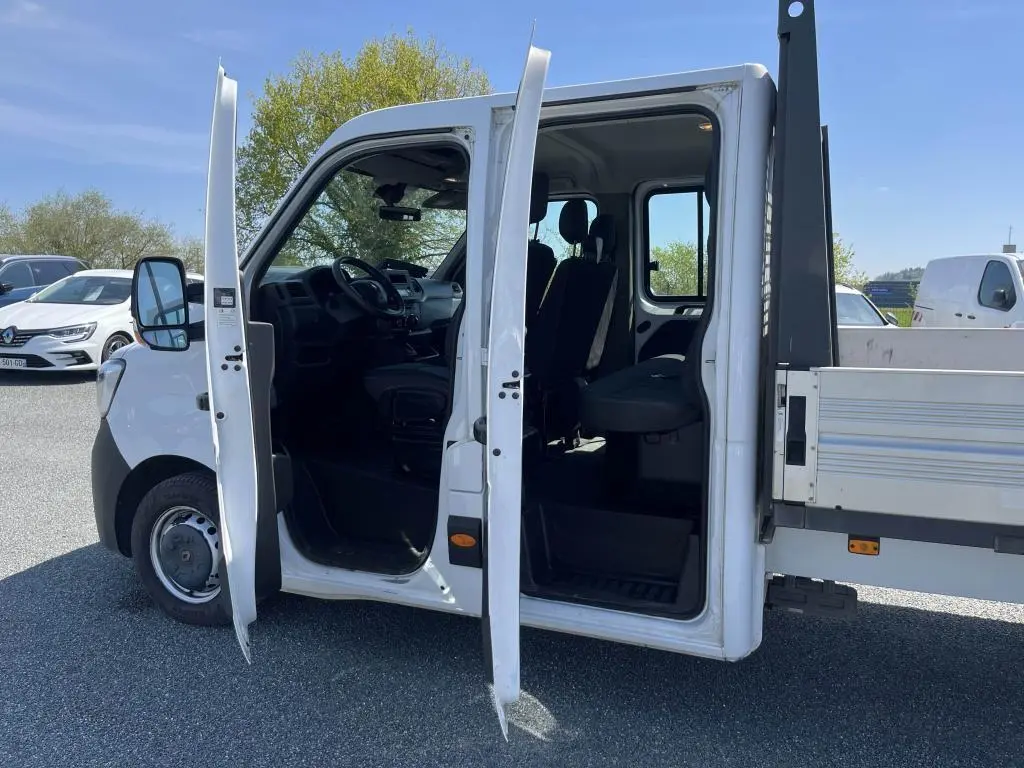 Vue latérale gauche d'un Renault Master blanc 2020 avec portes ouvertes montrant la cabine double et le plateau ridelles.