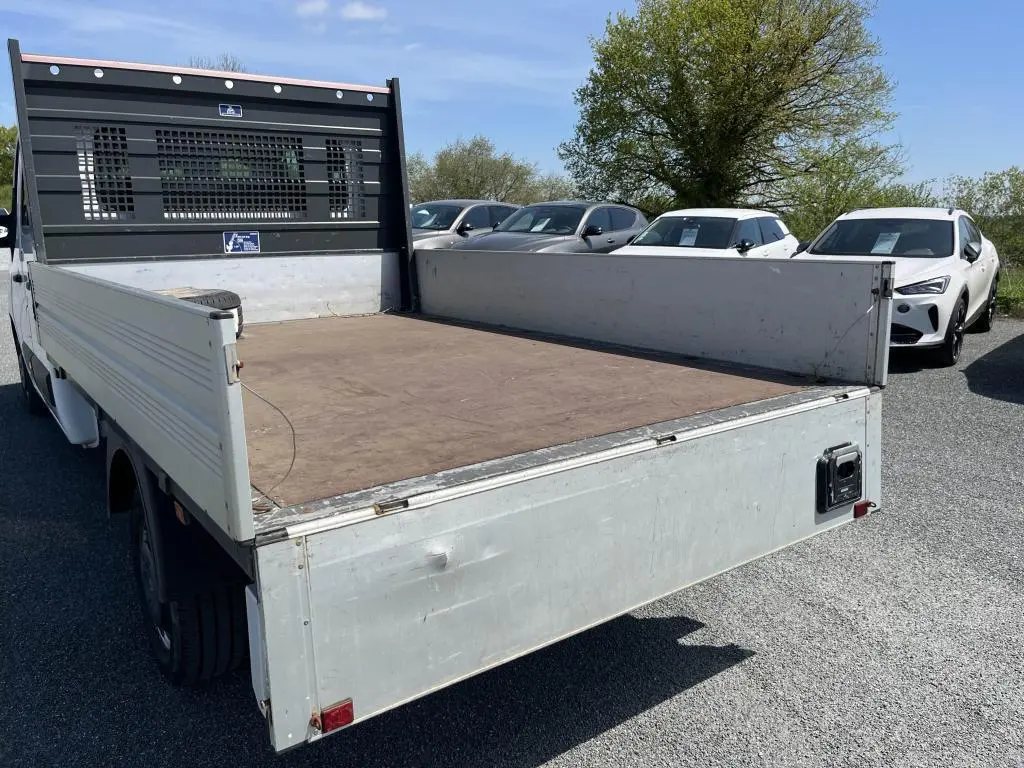 Vue arrière en 3/4 gauche du Renault Master blanc avec plateau ridelles aluminium et cabine double.