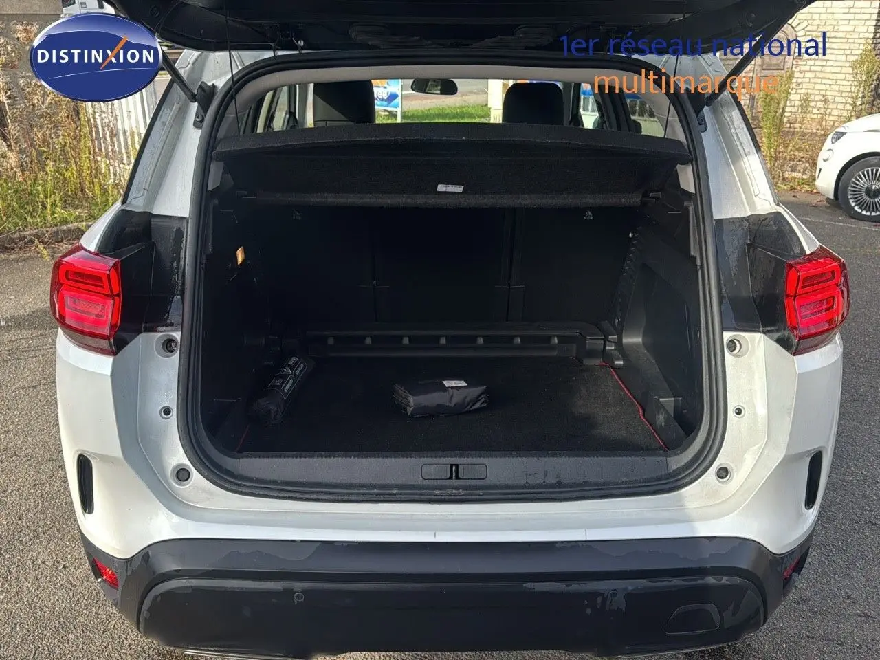 Vue arrière ouverte du Citroën C5 Aircross blanc nacré 2020, coffre spacieux avec cache-bagages déployé.