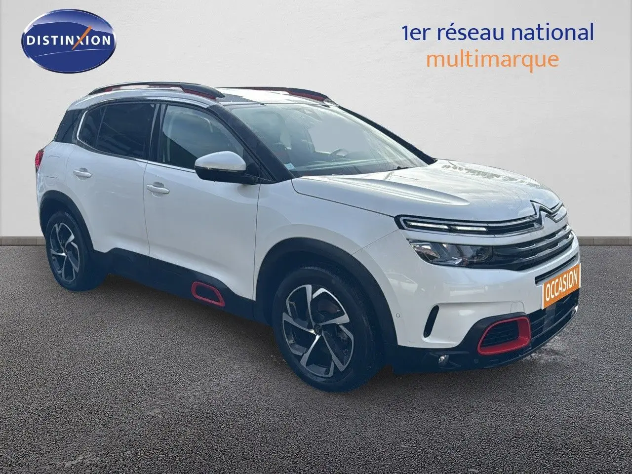 Citroën C5 Aircross blanc nacré en 3/4 avant droit avec détails rouges sur boucliers et bas de caisse.