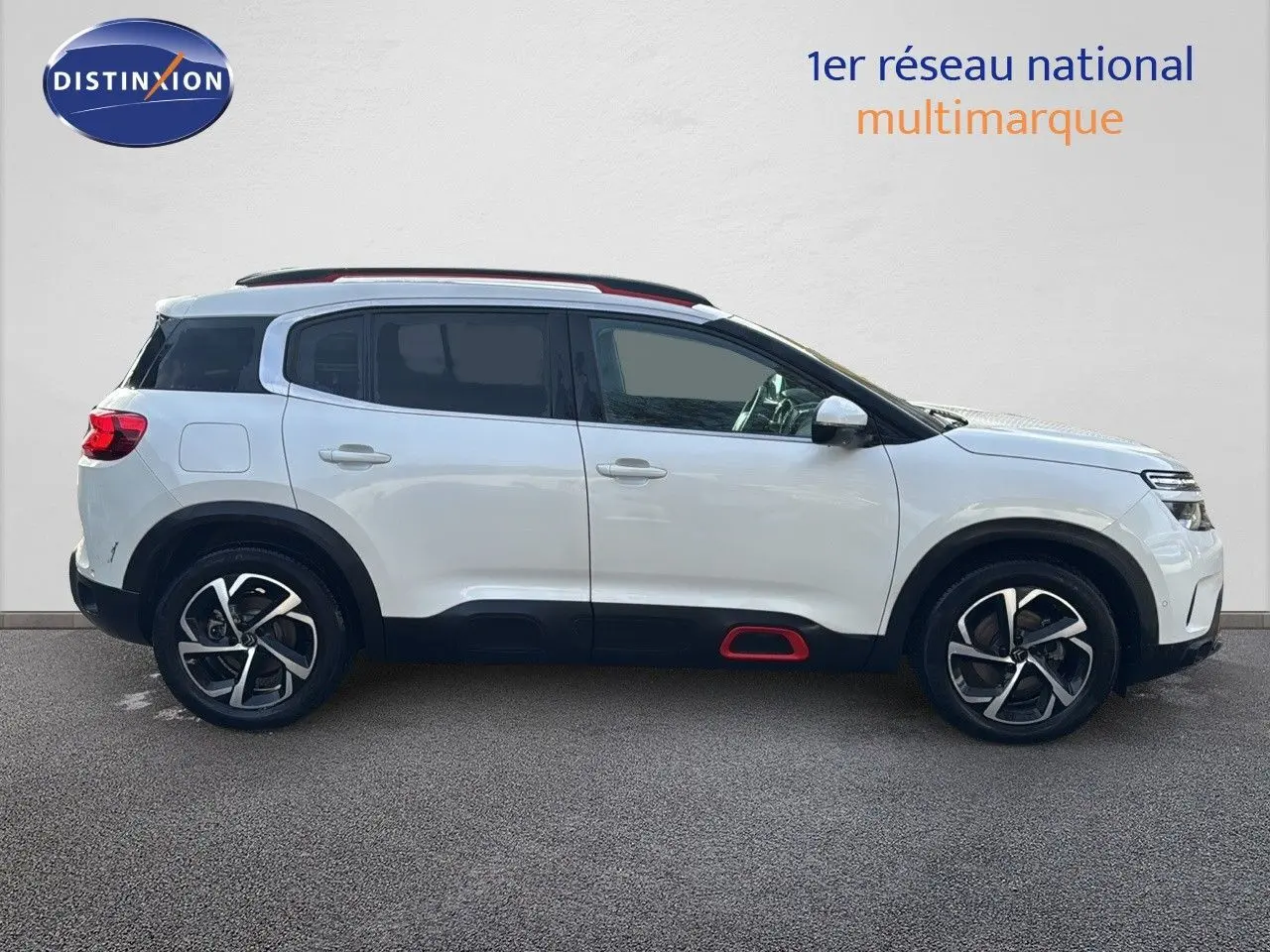 Citroën C5 Aircross blanc nacré vu de profil côté gauche, avec jantes alliage et inserts rouges sur bas de caisse.