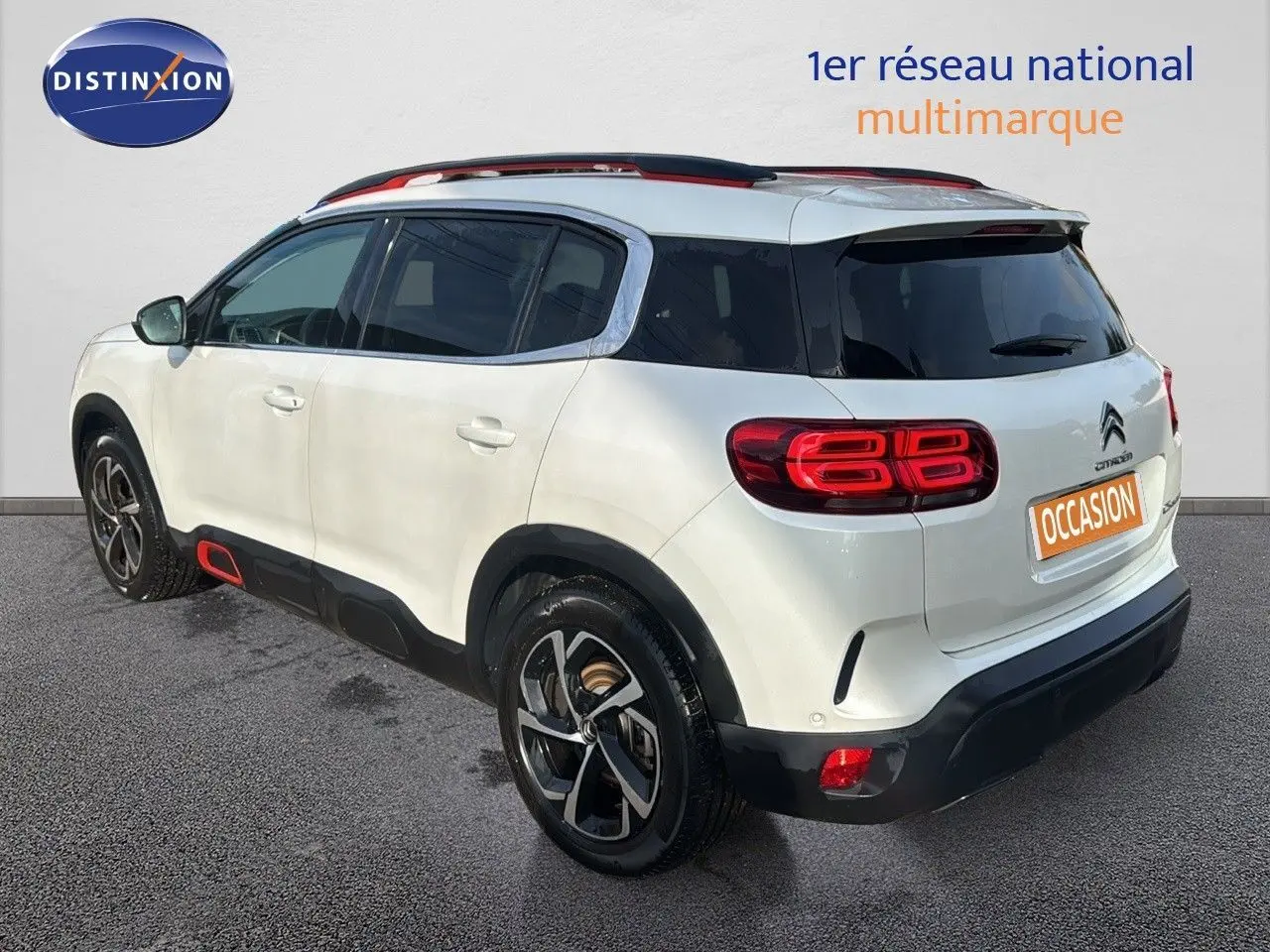 Vue 3/4 arrière droite d'un Citroën C5 Aircross blanc nacré avec détails rouges et jantes noires.