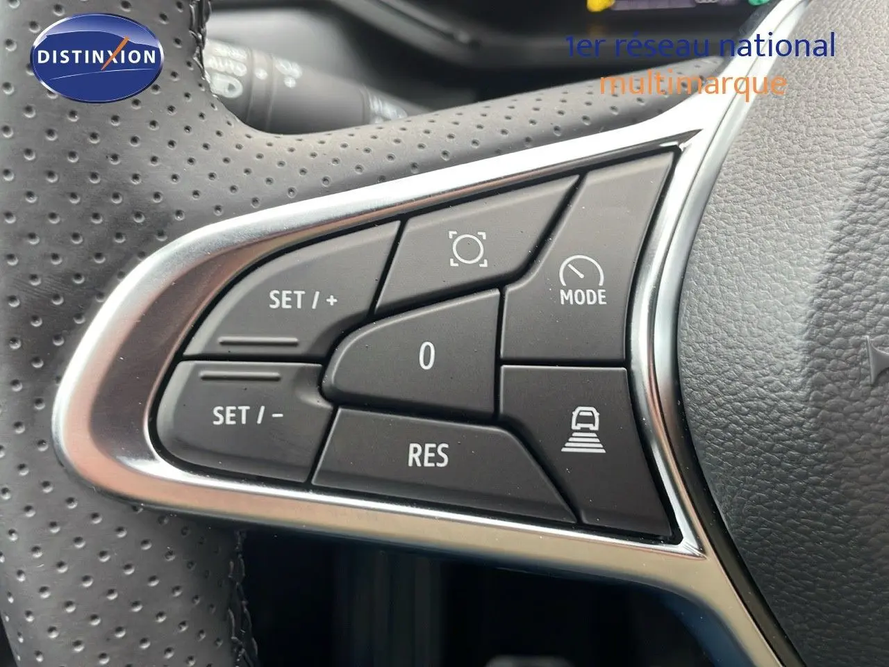 Gros plan sur les commandes de régulateur de vitesse au volant perforé du Renault Captur noir étoile métal 2025.