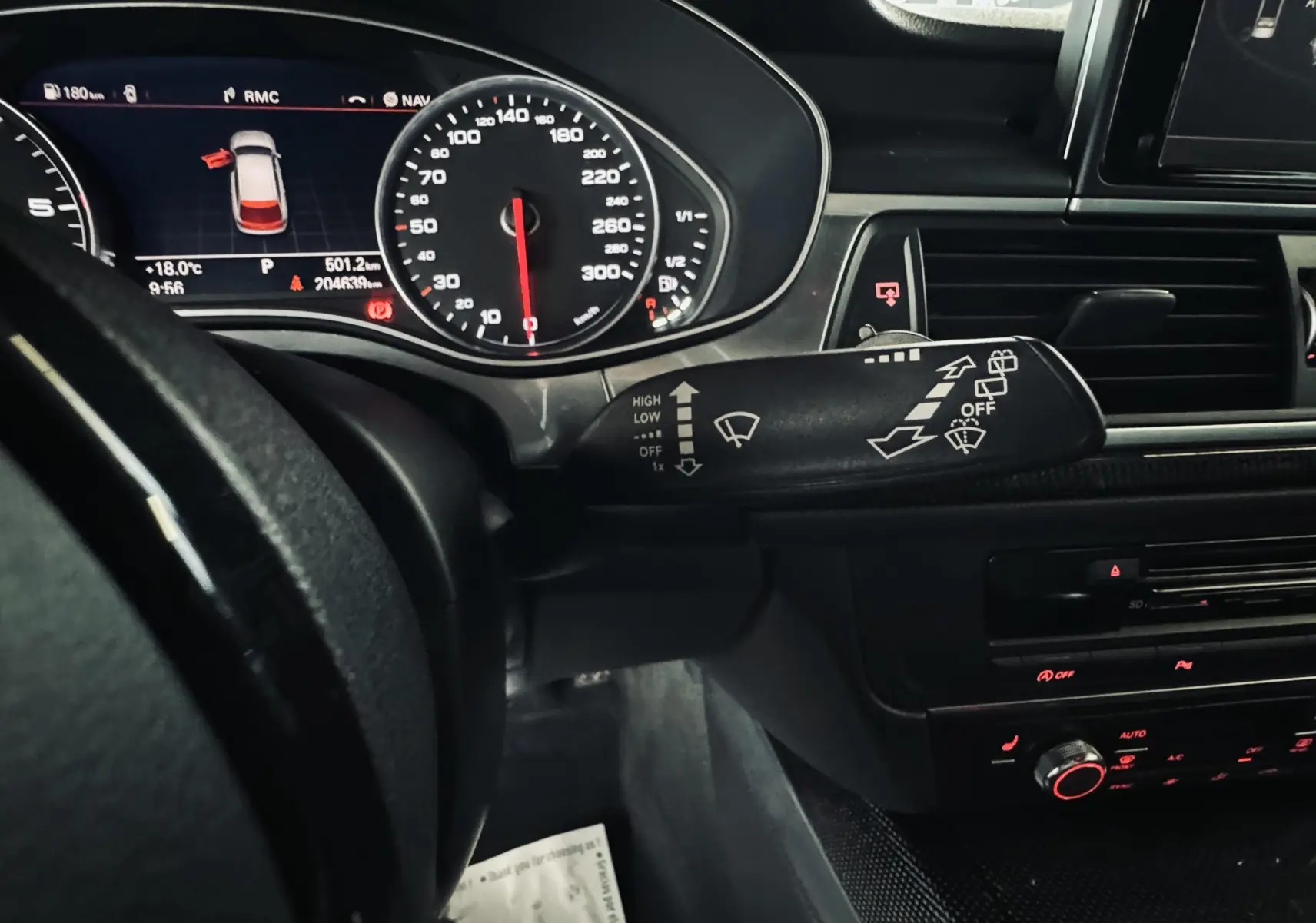 Vue rapprochée de l'intérieur noir de l'Audi A6 Avant Allroad 2016, tableau de bord et commandes au volant visibles.