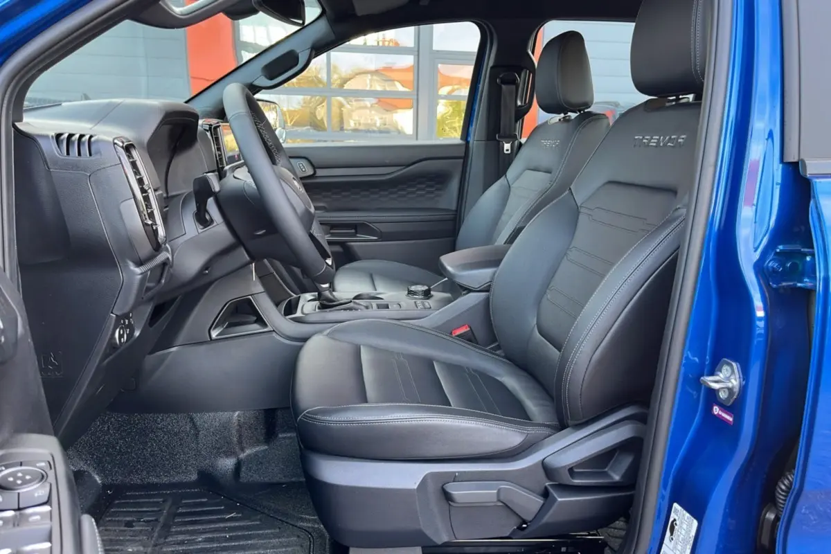 Intérieur côté conducteur du Ford Ranger 2025 bleu lightning, sièges en cuir noir avec logo Tremor brodé.