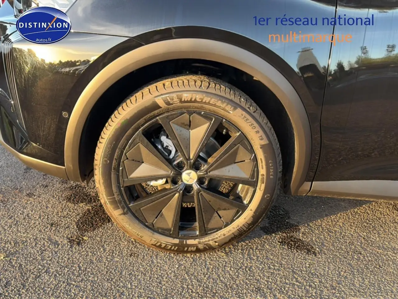 Gros plan sur la roue arrière droite noire d’un DS7 1.5 BlueHDi 130 Performance Line noir avec jante alu stylisée.