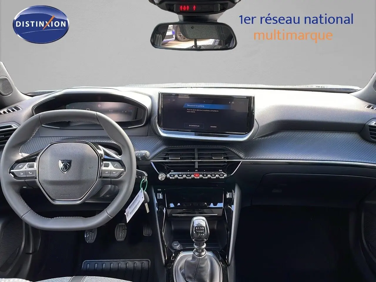 Intérieur Peugeot 2008 2025 vue avant du tableau de bord avec volant compact, écran tactile et levier de vitesse manuel.