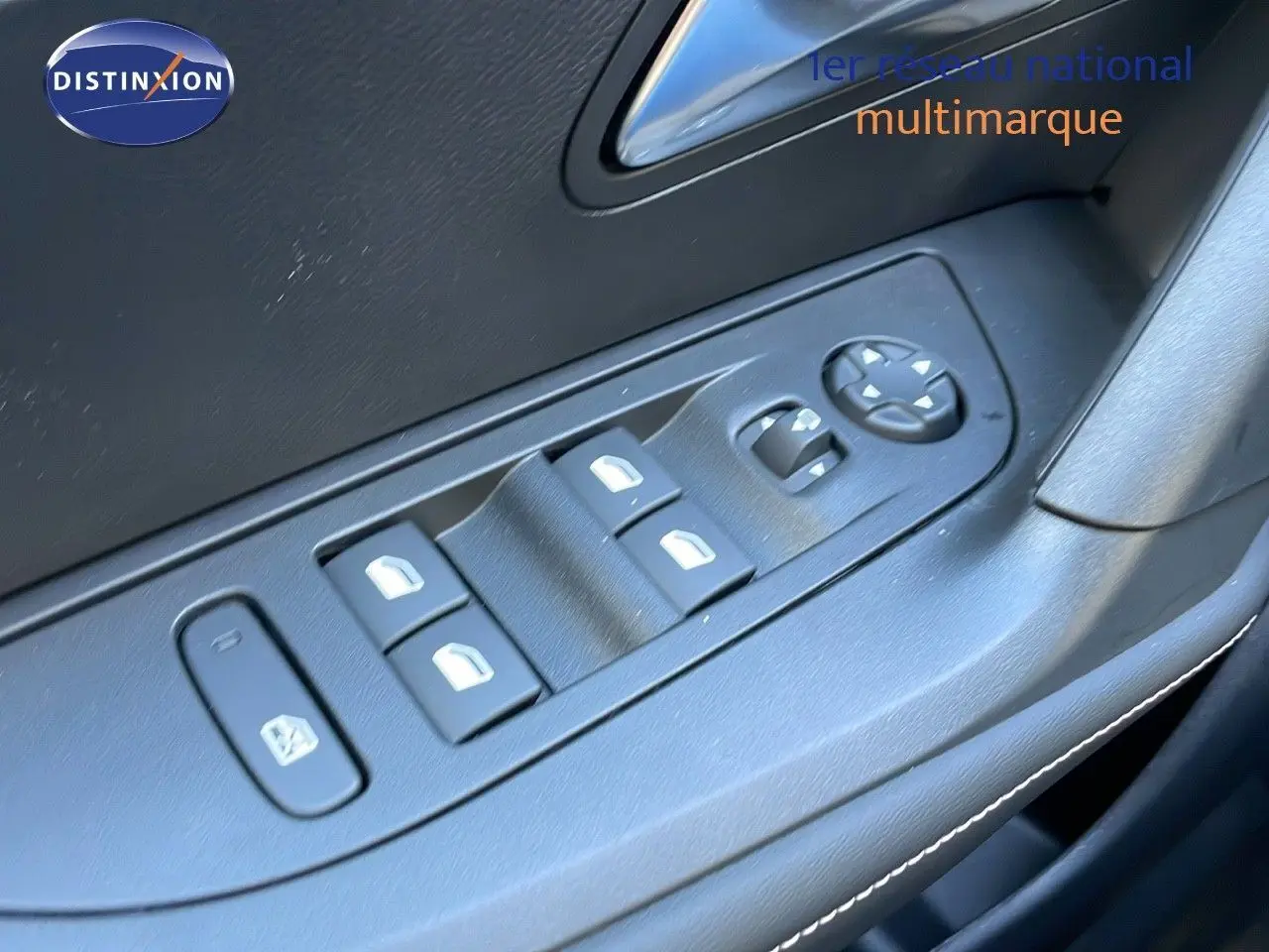 Commandes des vitres électriques et réglages des rétroviseurs sur la porte côté conducteur d'un Peugeot 2008 gris Artense 2025.