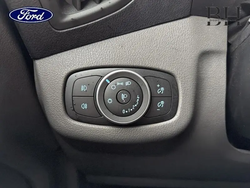 Gros plan sur le panneau de commande des phares du Ford Transit Connect blanc glacier, intérieur côté conducteur.