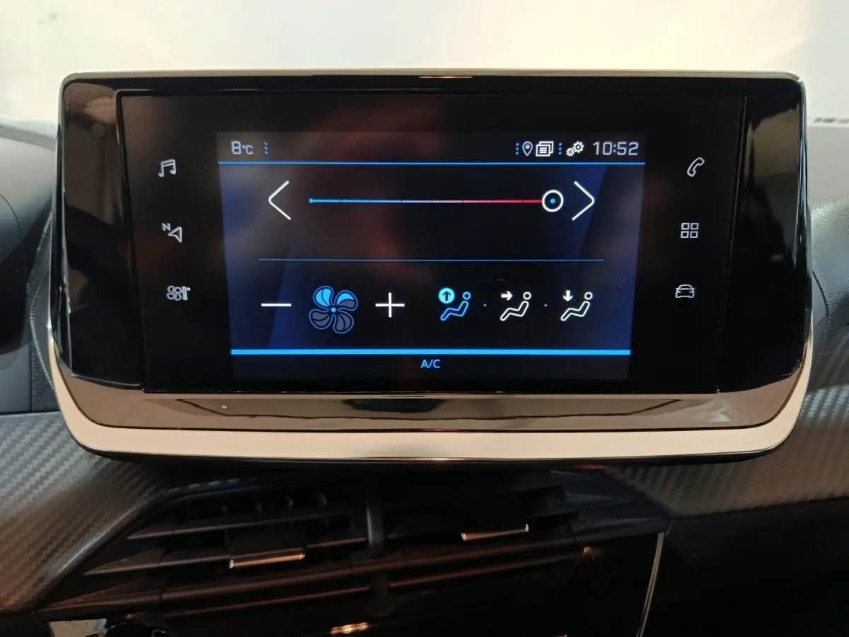 Écran tactile central de la Peugeot 208 noir affichant les réglages de la climatisation en gros plan.