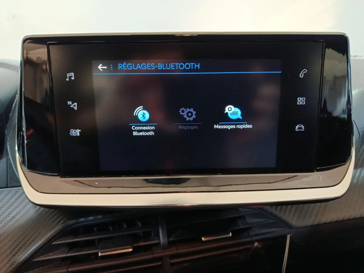 Écran tactile central affichant les réglages Bluetooth dans l'habitacle noir de la Peugeot 208 1.2 PT 75 S&S Premium.