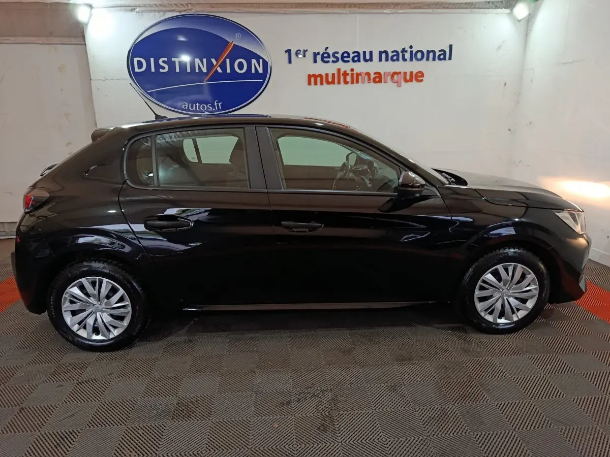 Profil côté gauche d'une Peugeot 208 noire 2022, finition Premium, avec jantes alliage et vitres teintées, en intérieur showroom.