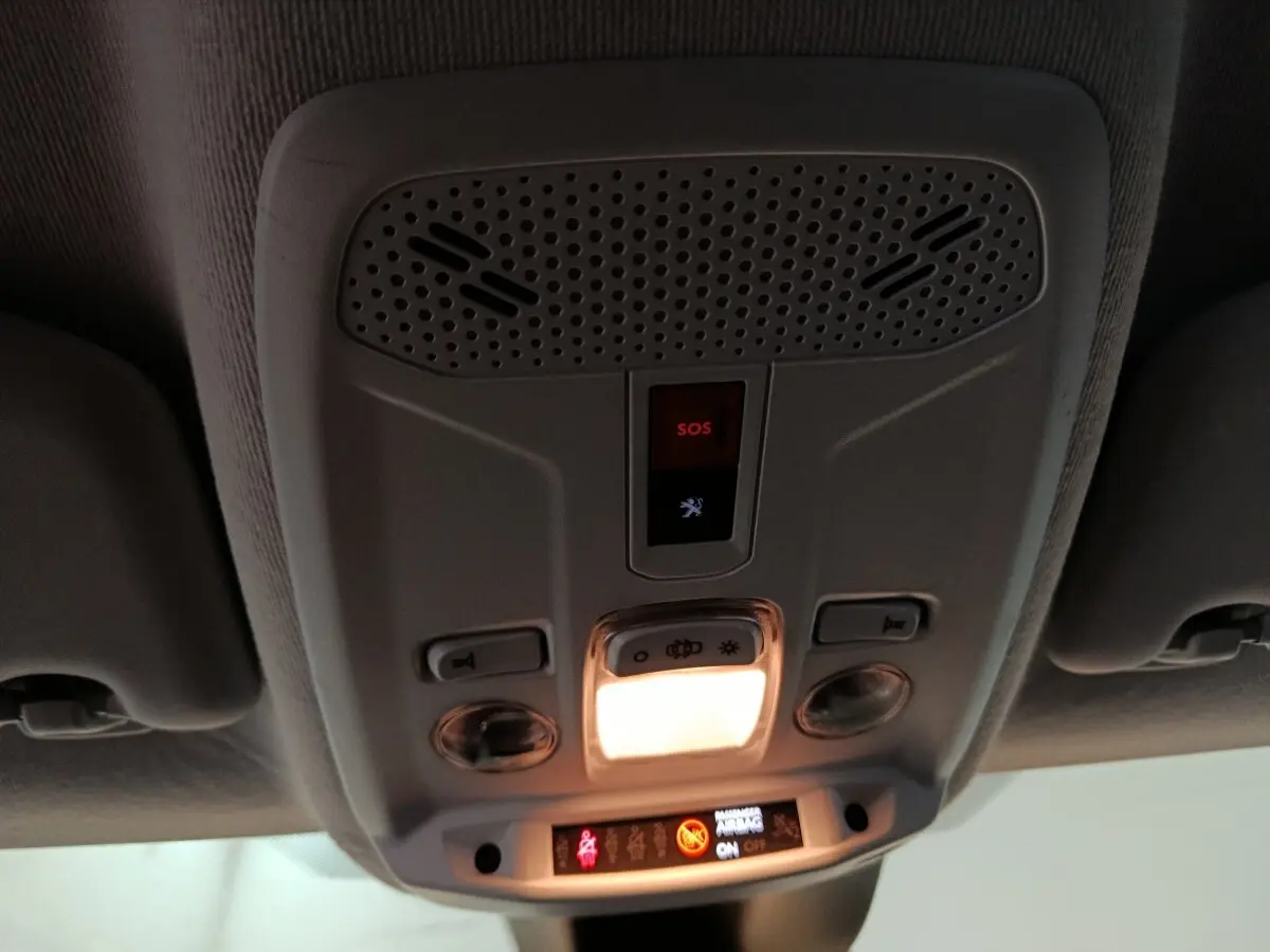 Vue intérieure du plafonnier avant de la Peugeot 208 noir 2022 avec bouton SOS et éclairage allumé.