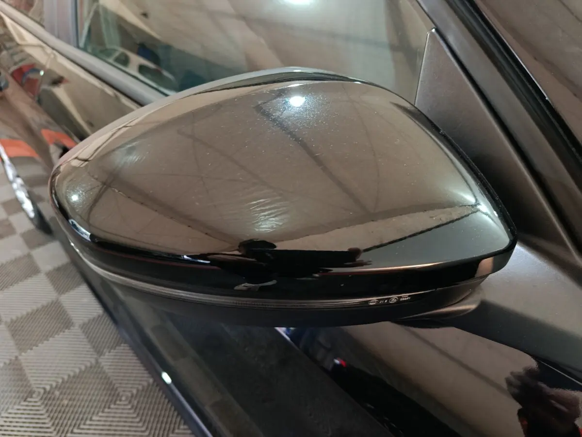 Rétroviseur côté gauche noir brillant de la Peugeot 208 1.2 PT 75 S&S Premium vue en gros plan.