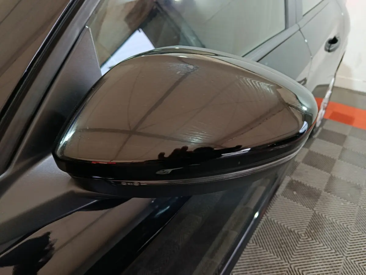 Rétroviseur côté gauche noir brillant de la Peugeot 208 1.2 PT 75 S&S Premium 2022, vue rapprochée en intérieur.