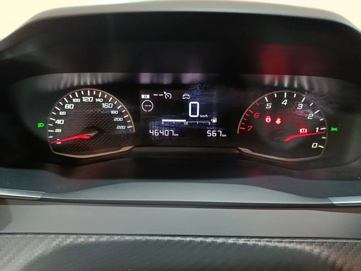 Vue rapprochée du tableau de bord numérique de la Peugeot 208 1.2 PT 75 S&S Premium avec affichage digital et compteurs analogiques.