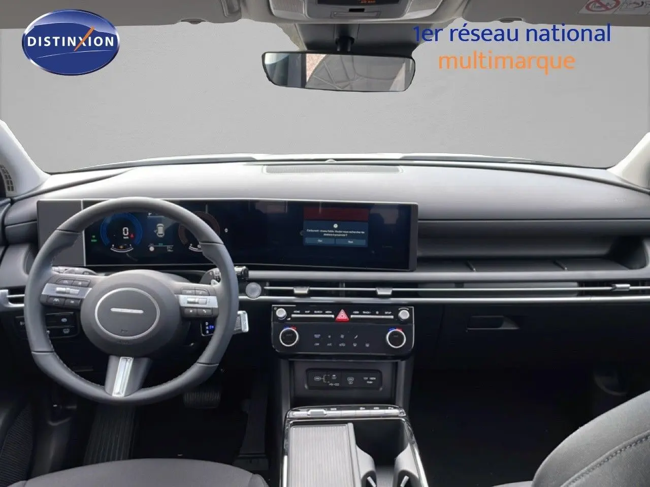 Vue intérieure frontale du tableau de bord noir du Hyundai Tucson 2026 avec écran large et volant multifonction.