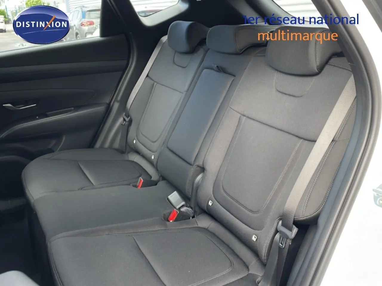 Vue intérieure côté arrière droit du Hyundai Tucson blanc Atlas 2026, montrant les sièges arrière en tissu noir.