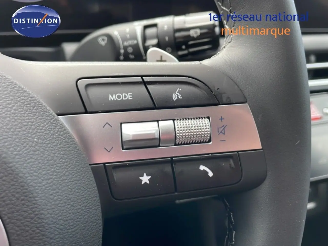 Gros plan sur les commandes multimédia et volume sur le volant noir du Hyundai Tucson blanc Atlas 2026.