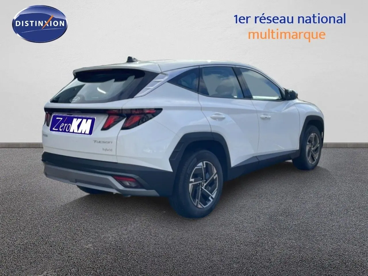 Vue 3/4 arrière droite du Hyundai Tucson blanc Atlas 2026 avec jantes biton et feux arrière LED distinctifs.