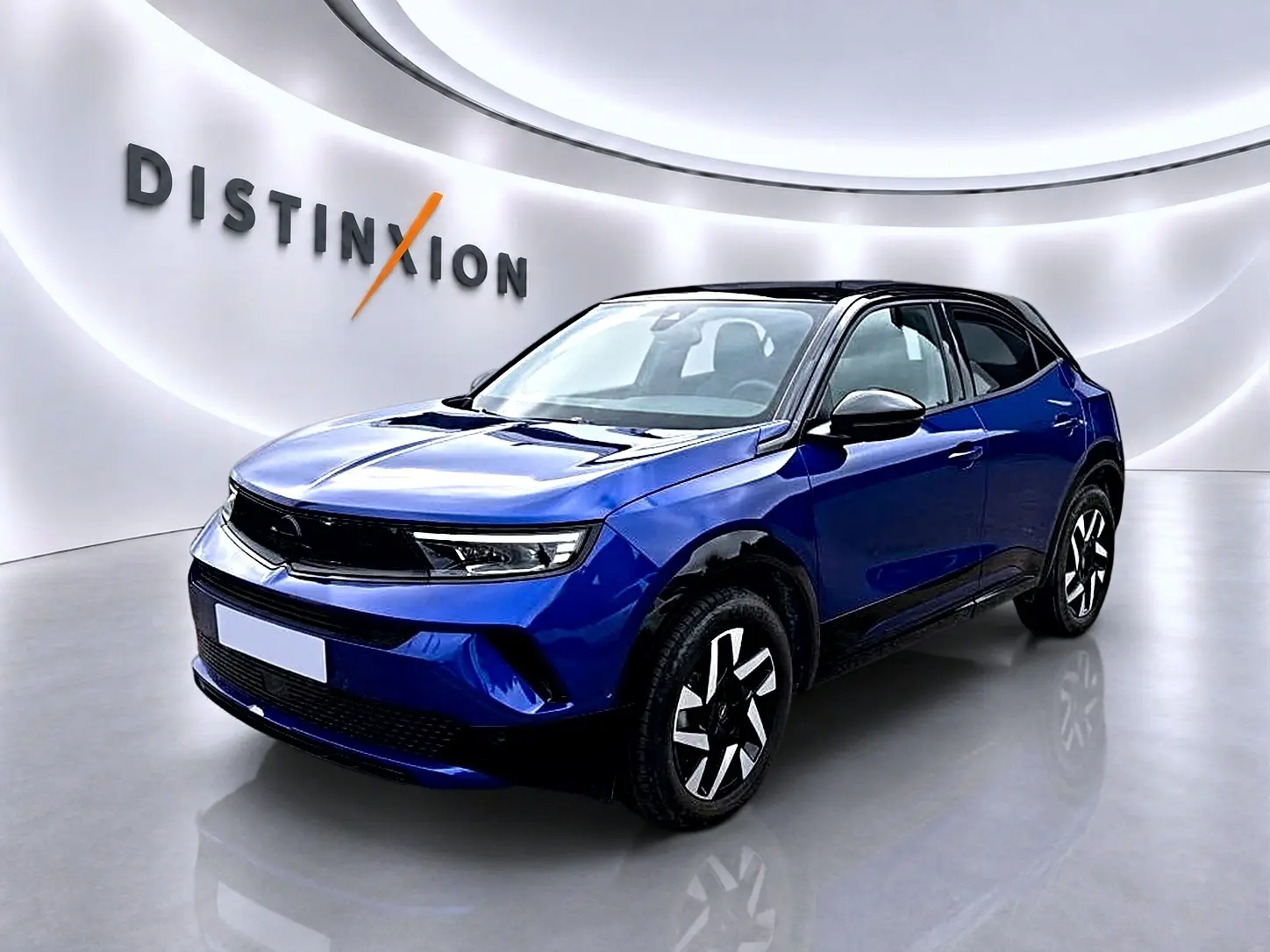 Opel Mokka 1.2 turbo bleu en 3/4 avant droit, toit noir et jantes au design moderne dans un studio lumineux.