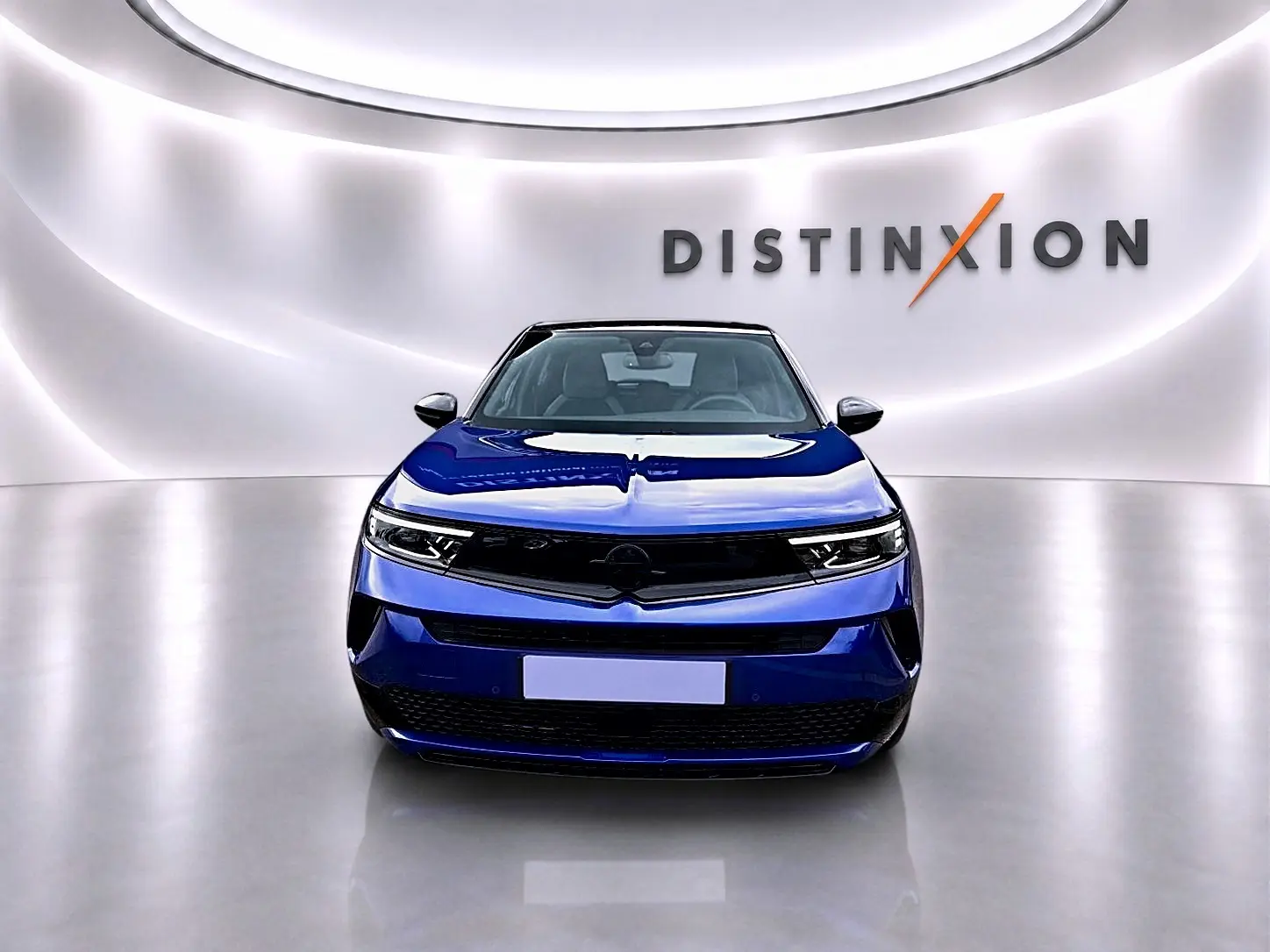 Vue frontale d'un Opel Mokka 1.2 turbo 136 edition bleu, avec calandre noire et phares LED fins dans un showroom lumineux.