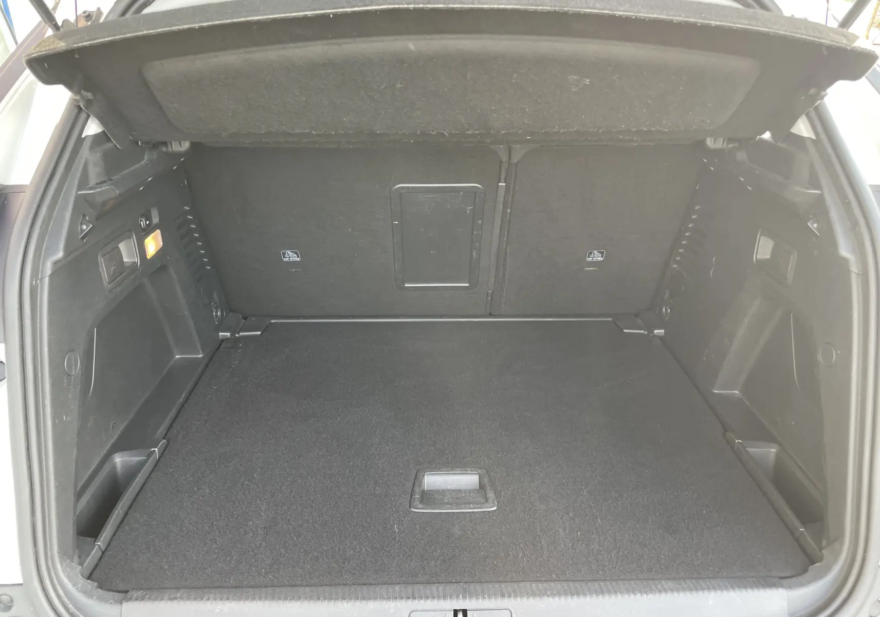 Coffre ouvert du Peugeot 3008 blanc vue de l'arrière, montrant un espace de chargement propre et bien agencé.