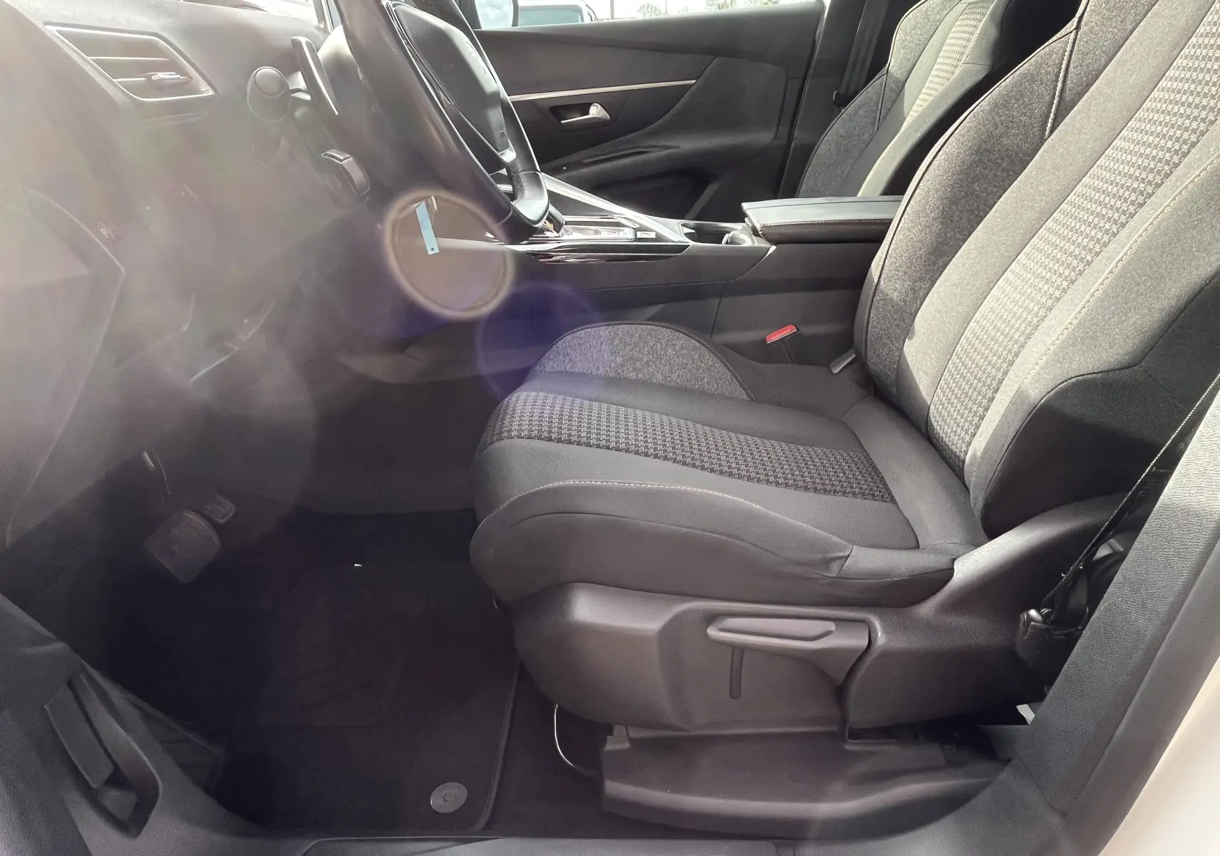 Vue intérieure côté conducteur du Peugeot 3008 blanc de 2018, mettant en valeur les sièges gris noir et la console centrale moderne.