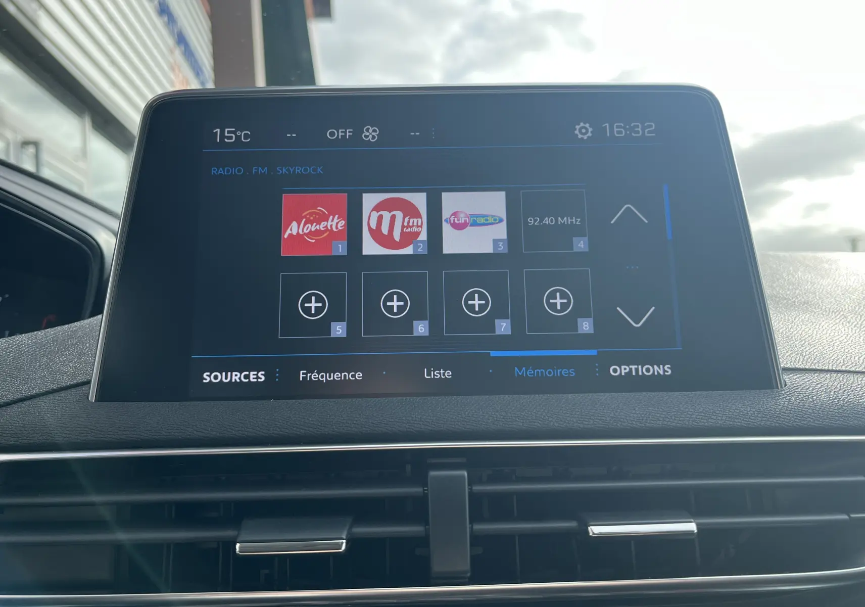 Écran tactile central du Peugeot 3008 blanc 2018 affichant les stations radio FM avec commandes de climatisation visibles en dessous.