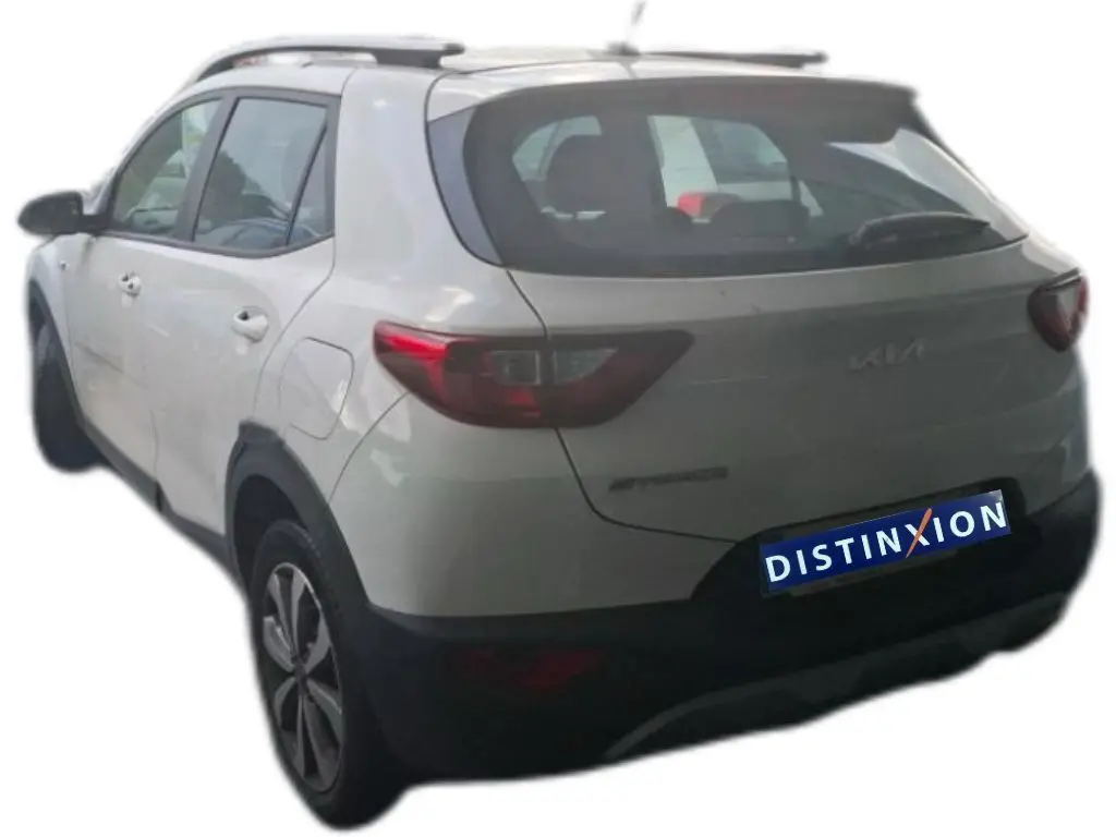 Vue 3/4 arrière gauche d'un KIA Stonic blanc 2022 avec toit noir et jantes alliage distinctives.