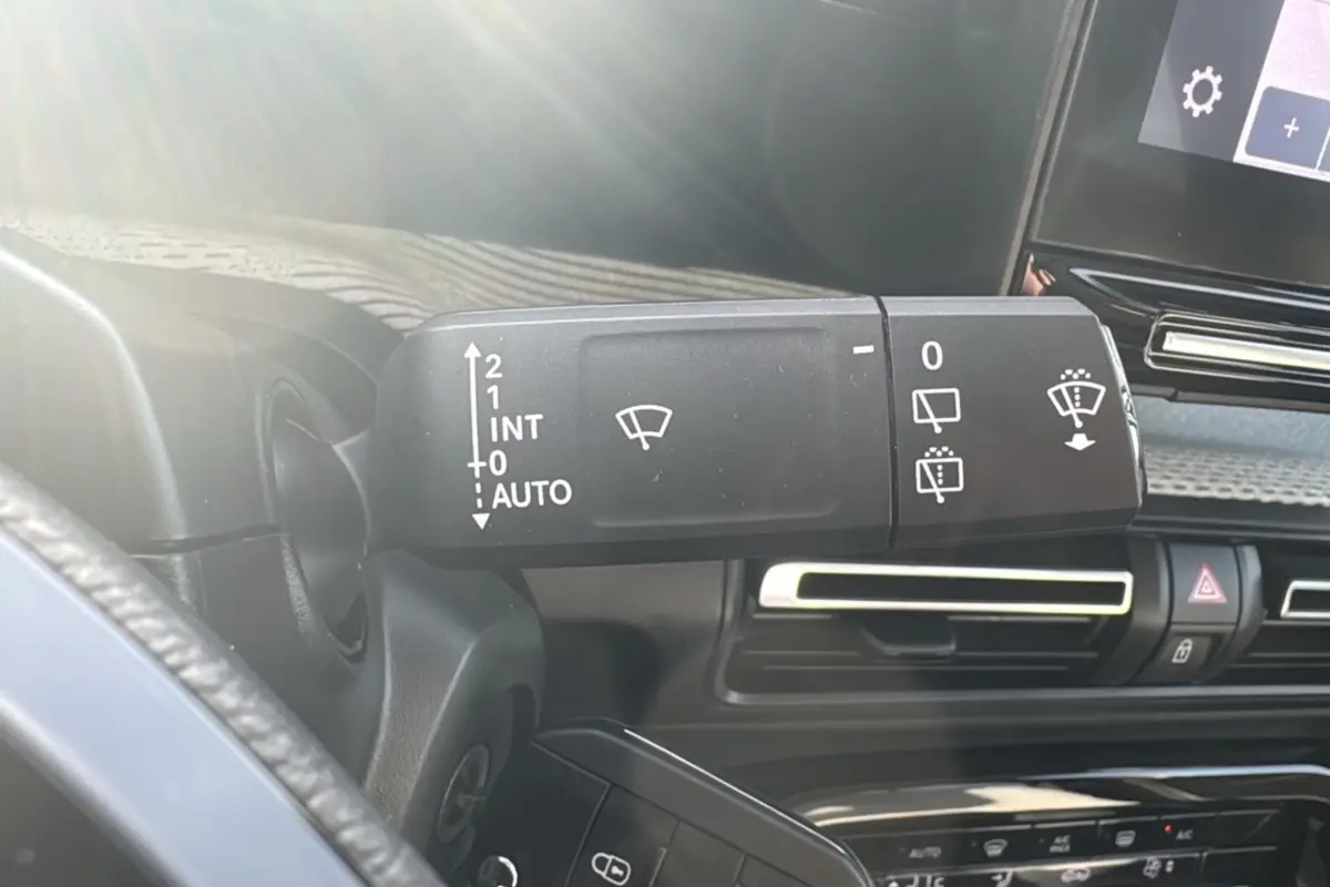 Gros plan sur la commande d’essuie-glace à gauche du volant dans l’habitacle sombre d’une Citroën C3 Aircross 2025.
