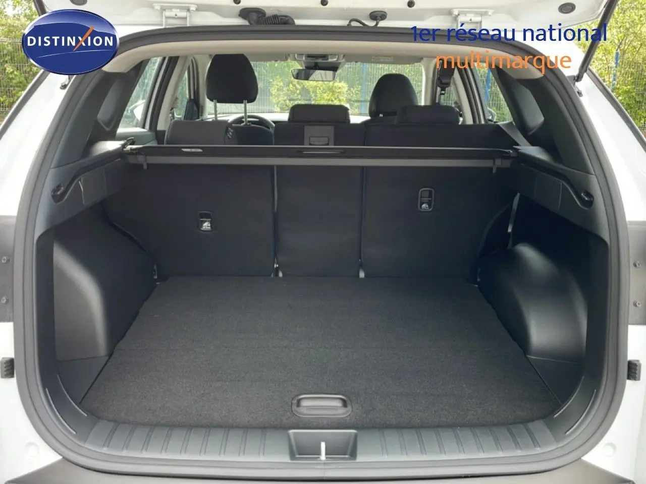 Vue arrière du coffre ouvert d'un Hyundai Tucson blanc Atlas 2026, montrant un espace de chargement spacieux et propre.