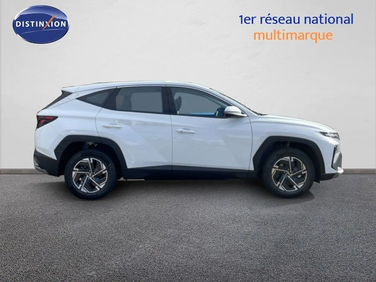 Profil droit du Hyundai Tucson blanc Atlas 2026 avec jantes bi-ton et lignes anguleuses marquées.