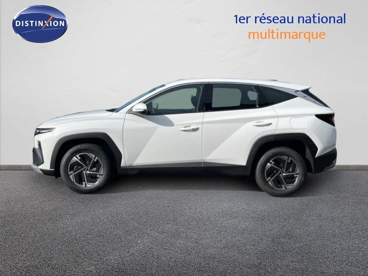 Vue latérale droite du Hyundai Tucson blanc Atlas 2026 avec jantes biton et détails noirs contrastants.