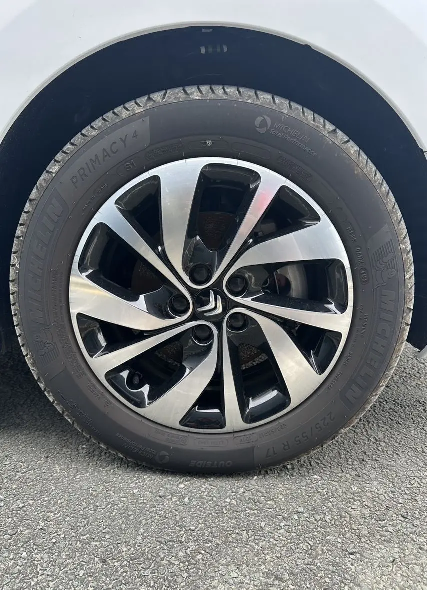 Gros plan sur la jante aluminium 17 pouces bicolore avec logo Citroën, montée sur un van blanc Citroën Jumpy électrique.