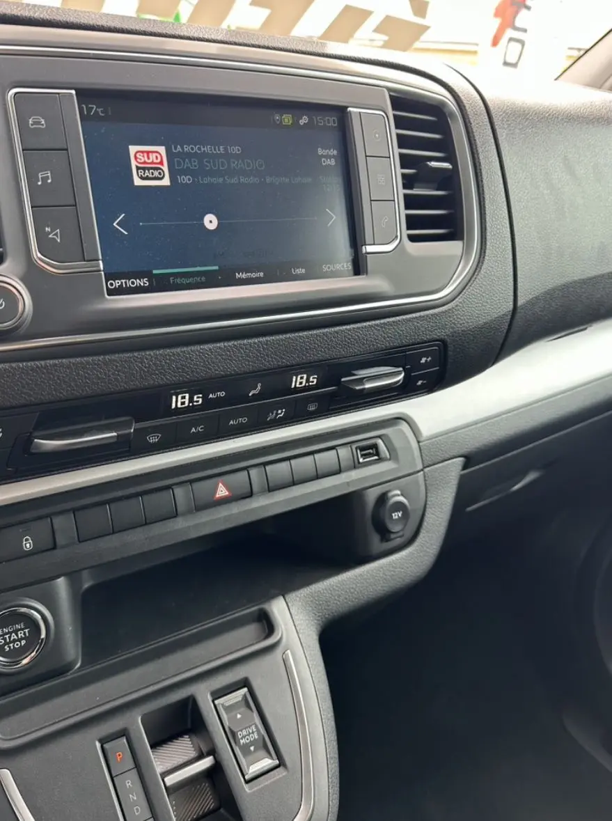 Tableau de bord du Citroën Jumpy van électrique, vue intérieure côté passager avec écran tactile et commandes climatisation.