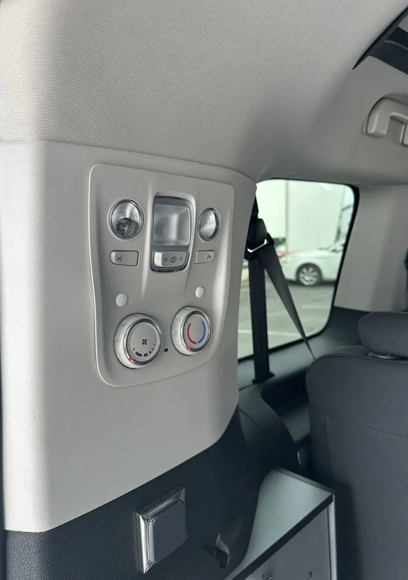 Vue intérieure arrière droite du Citroën Jumpy van blanc, panneau de commandes climatisation et éclairage au plafond.