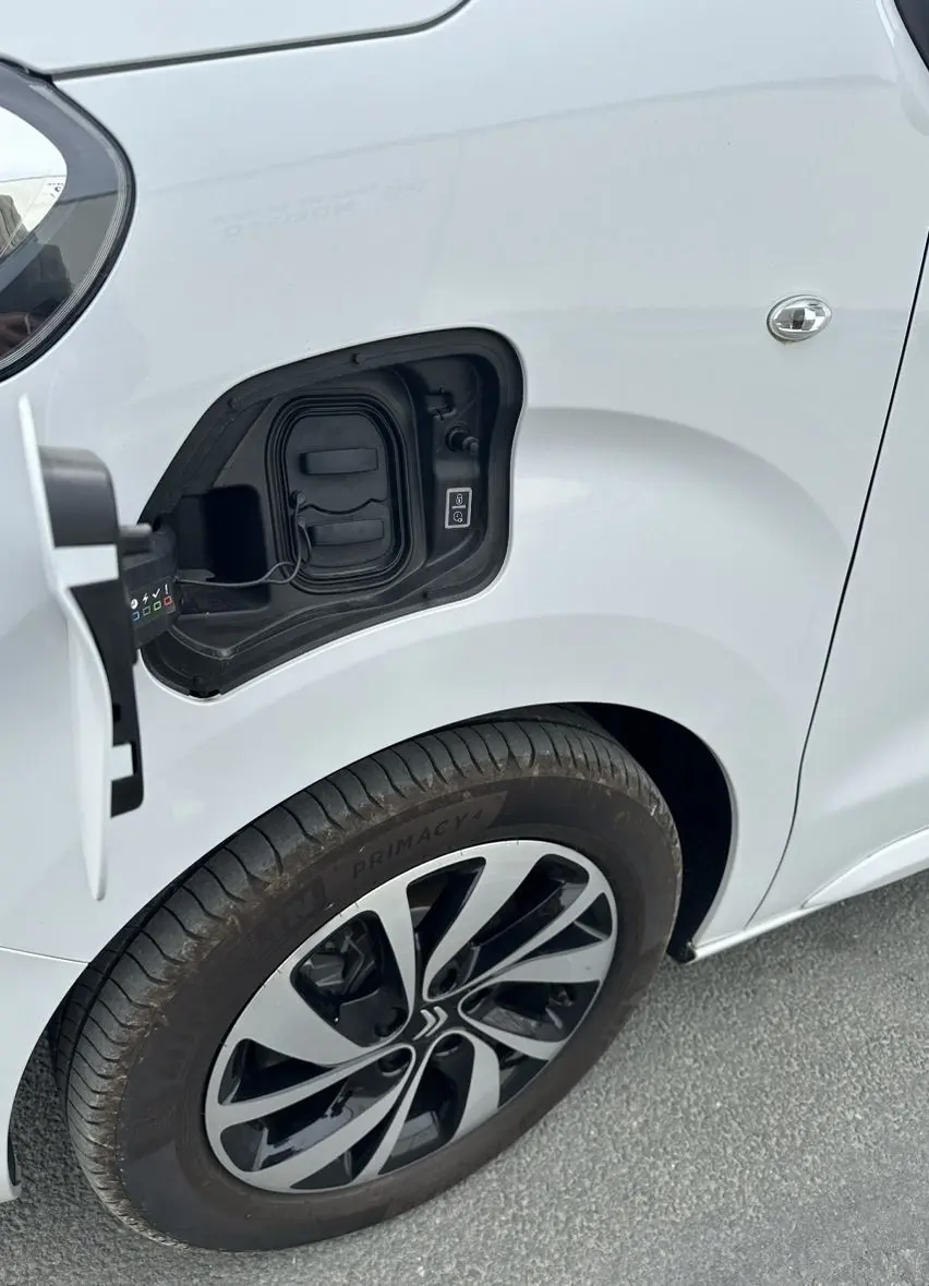 Gros plan sur la trappe de recharge ouverte côté avant gauche d’un Citroën Jumpy van blanc avec jante aluminium 17 pouces.