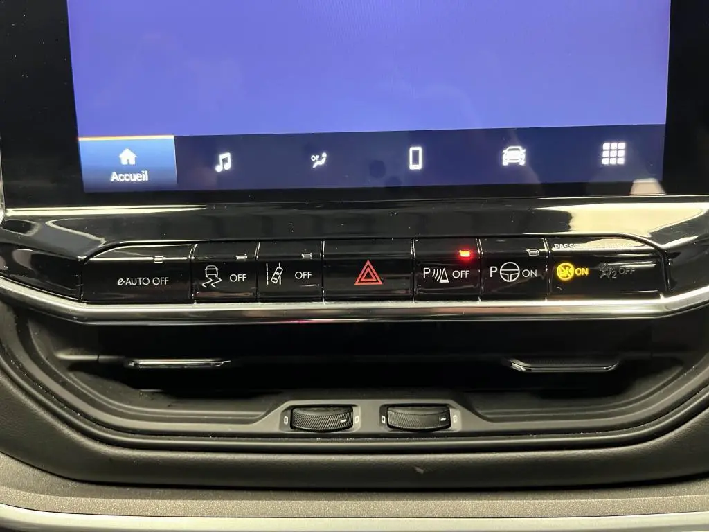 Tableau de bord du Jeep Compass 2024 avec boutons de contrôle et écran tactile affichant le menu principal.