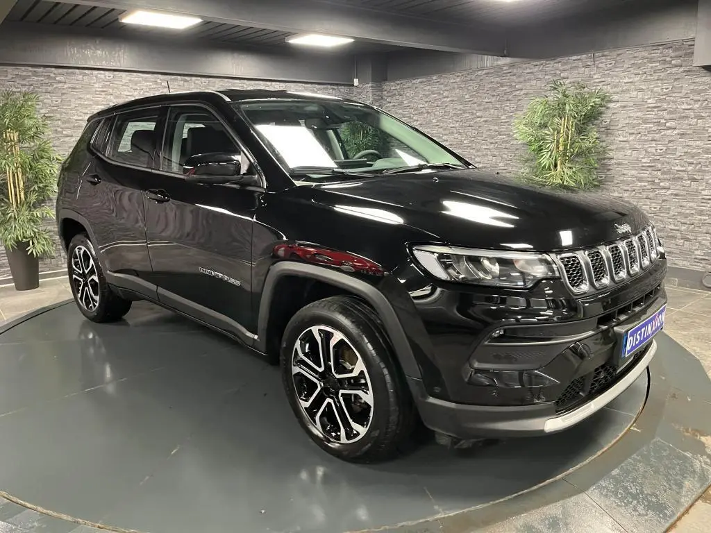 Jeep Compass 2024 noir en 3/4 avant droit, avec jantes alliage 18 pouces et calandre distinctive à sept fentes.