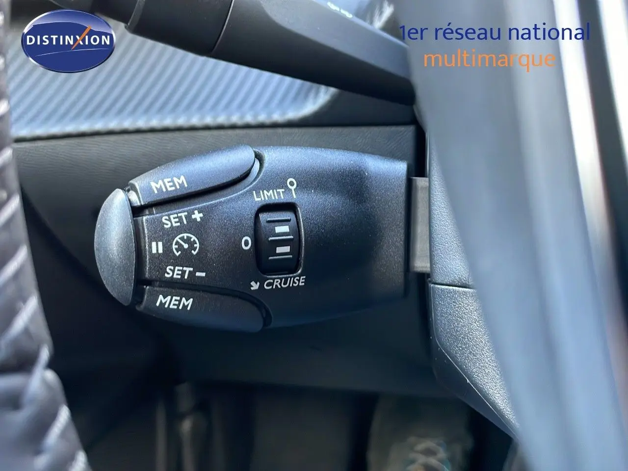 Gros plan sur la commande de régulateur de vitesse du Peugeot 2008 gris Artense, côté gauche du volant.