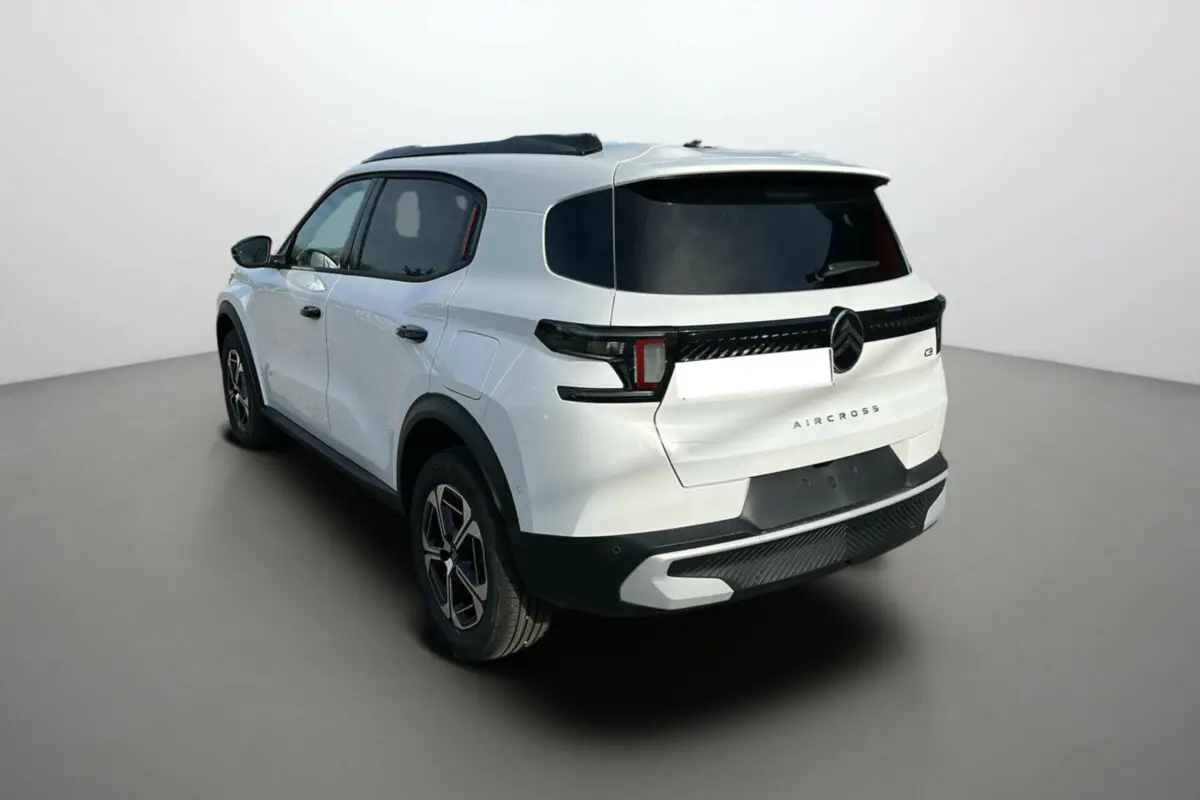 Vue 3/4 arrière droite d'un Citroën C3 Aircross blanc banquise avec vitres surteintées et jantes alu 17 pouces.