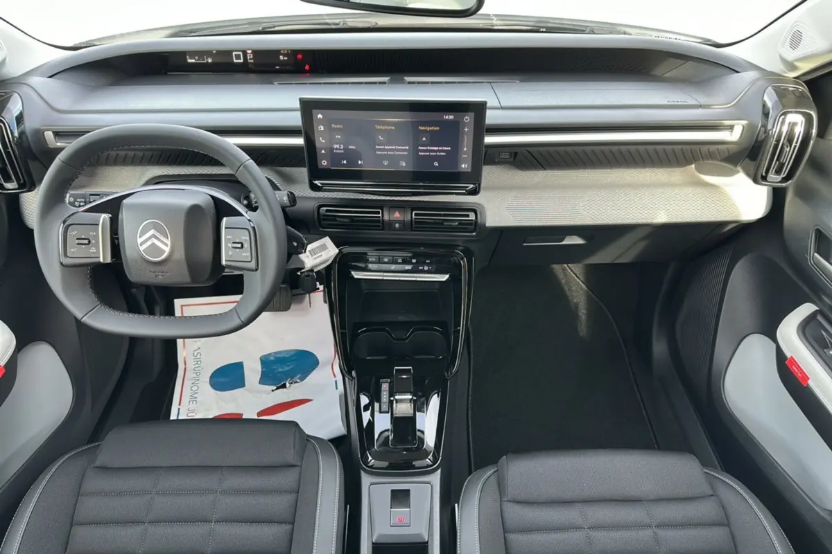 Intérieur moderne du Citroën C3 Aircross blanc banquise, vue frontale sur le tableau de bord et volant multifonctions cuir.