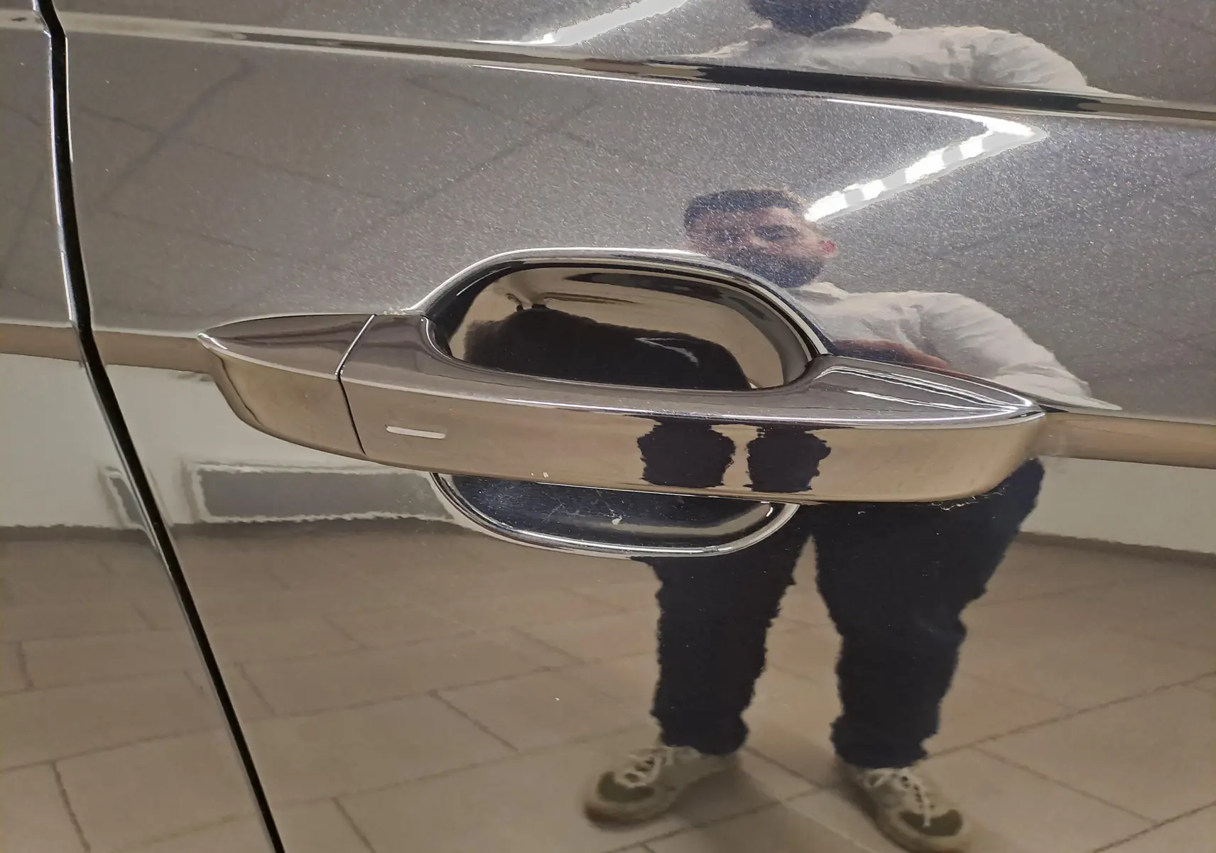 Poignée de porte côté gauche en chrome sur Volkswagen Taigo noir intense nacré avec reflet intérieur.