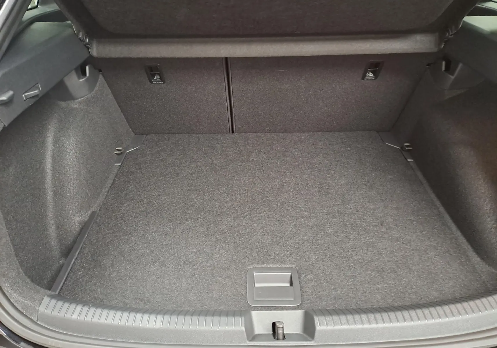 Coffre ouvert vu de face, intérieur gris avec revêtement tissu, sans chargement visible, Volkswagen Taigo 2025.