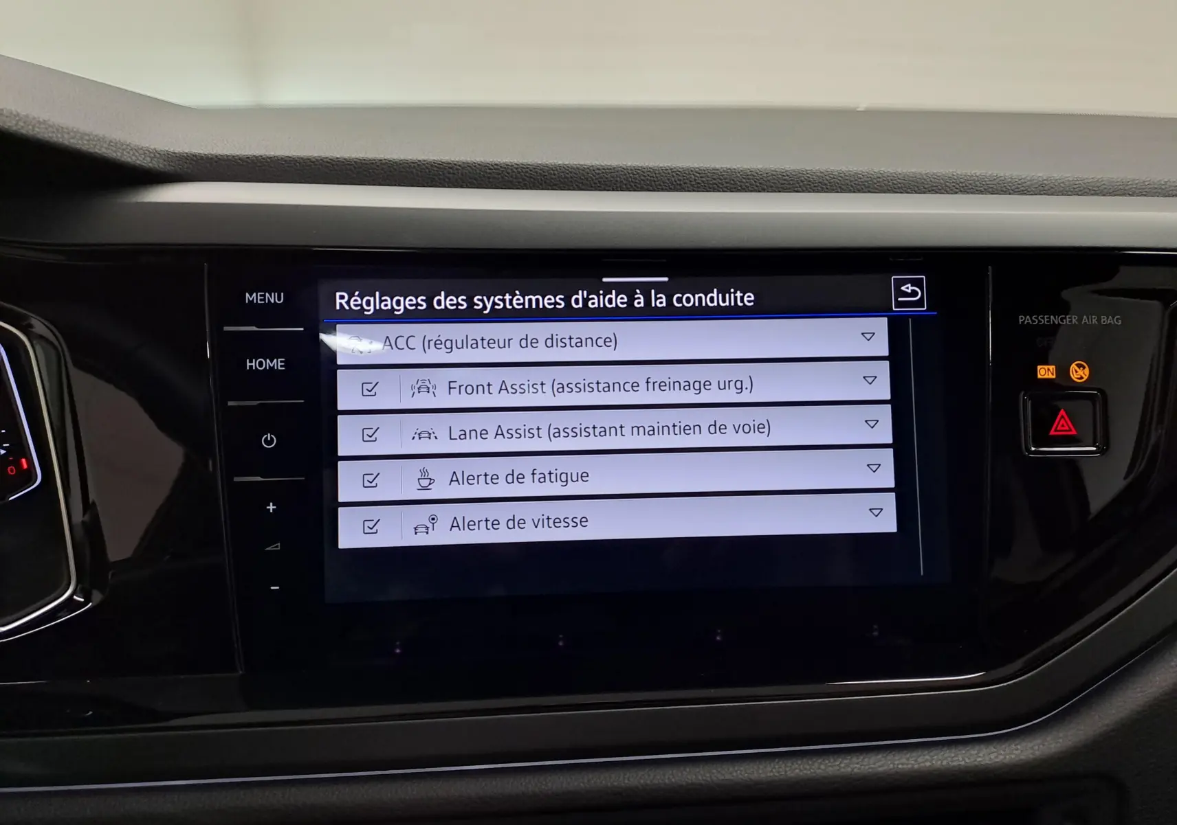 Écran tactile central du Volkswagen Taigo 2025 affichant les réglages des aides à la conduite, intérieur noir.
