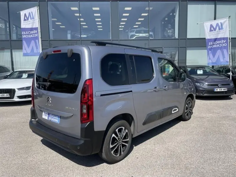 Vue 3/4 arrière droite d'un Citroën Berlingo gris métal 2018 avec vitres teintées et jantes alliage noires.