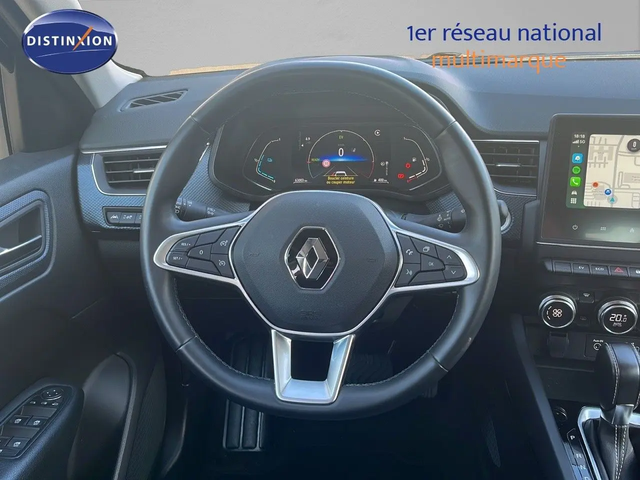 Vue intérieure centrée sur le volant du Renault Arkana noir métal, avec tableau de bord numérique et écran tactile visible à droite.