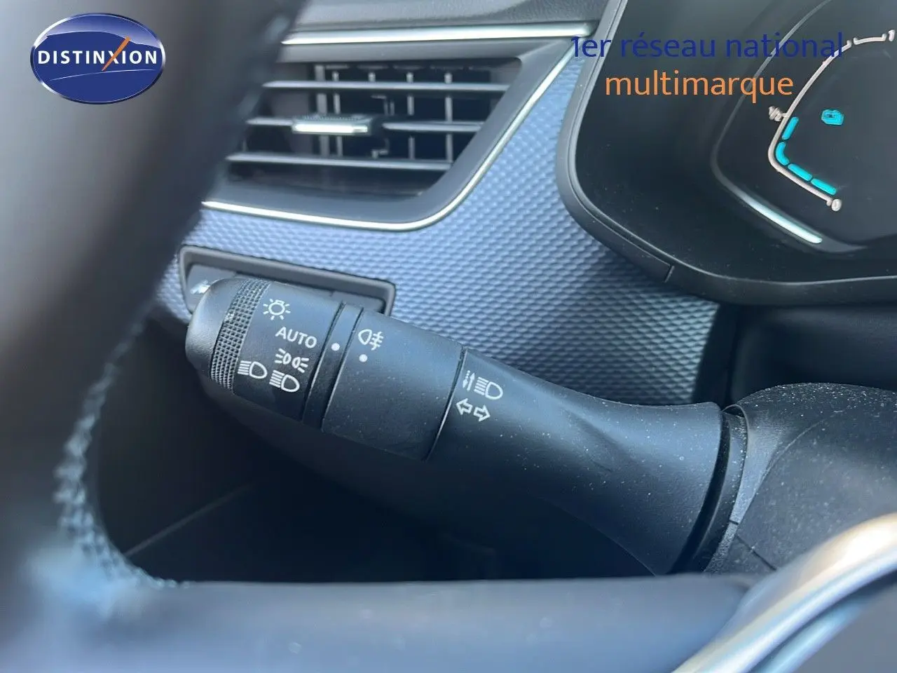 Gros plan sur la commande des feux et clignotants à gauche du volant dans l'habitacle gris du Renault Arkana noir métal 2023.